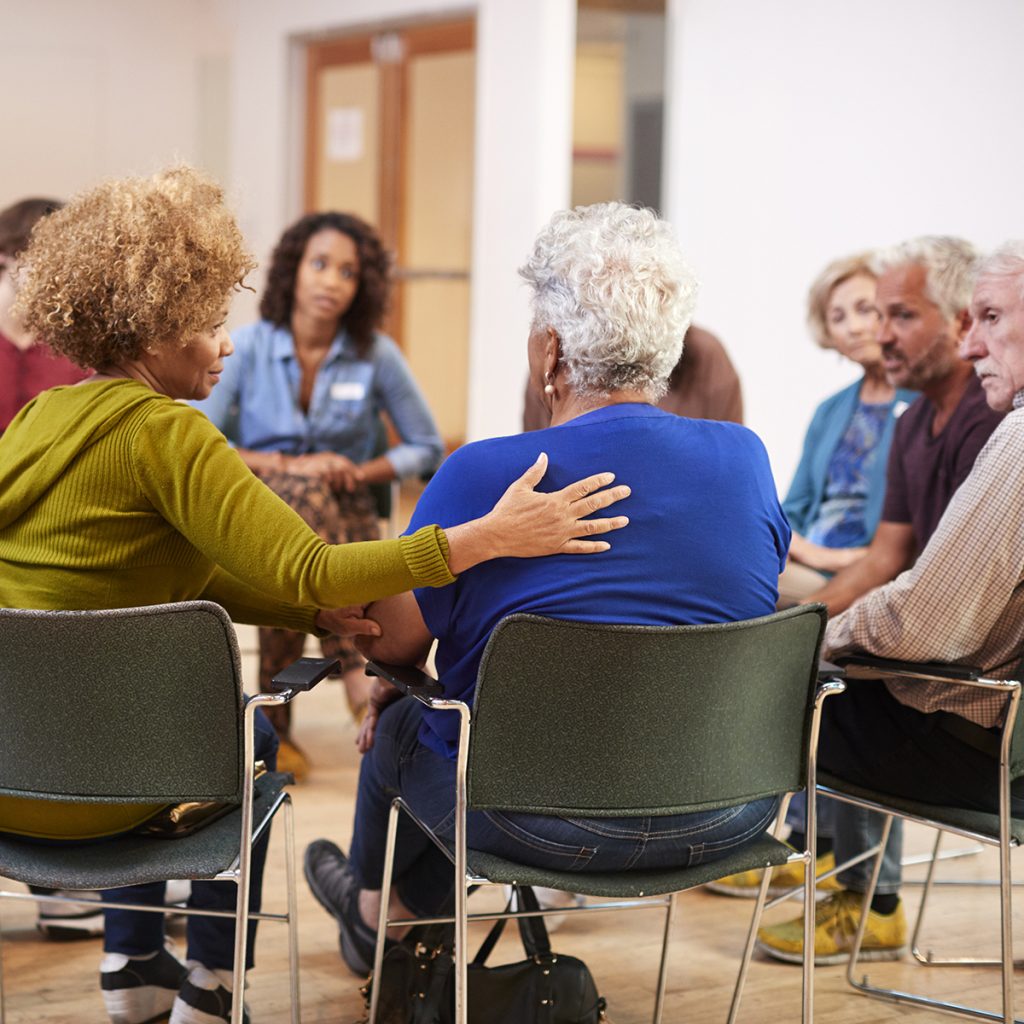 People Attending Self Help Therapy Group Meeting In Community Center